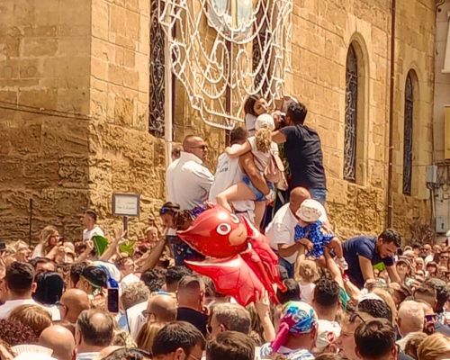 I devoti salgono sulla statua di San Calogero all'uscita dal santuario